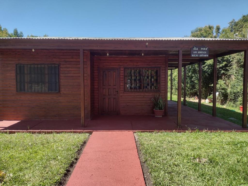 a wooden building with a door in the grass at Cabaña Óga Pora' in Puerto Yeruá