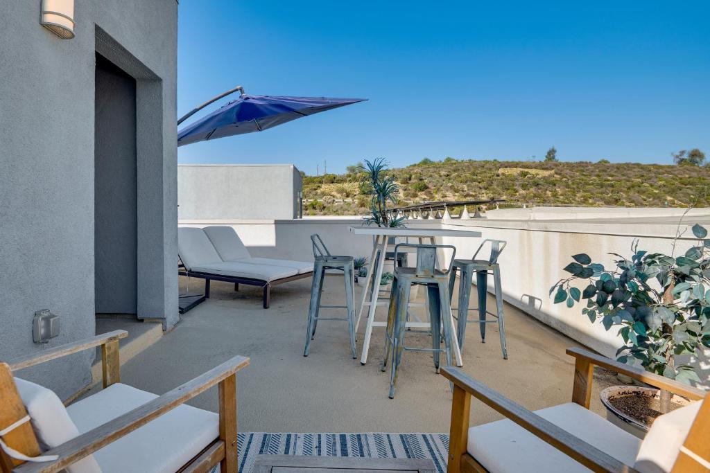 a balcony with a table and chairs and an umbrella at 12 Mi to DTLA! Multi-Level Charmer w/ Pool Access in Montebello