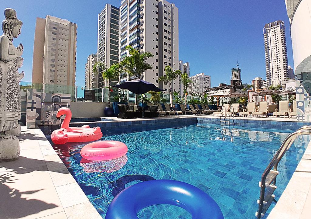 a swimming pool with a swan and a flamingo in a city at Hotel Sibara SPA & Convenções in Balneário Camboriú