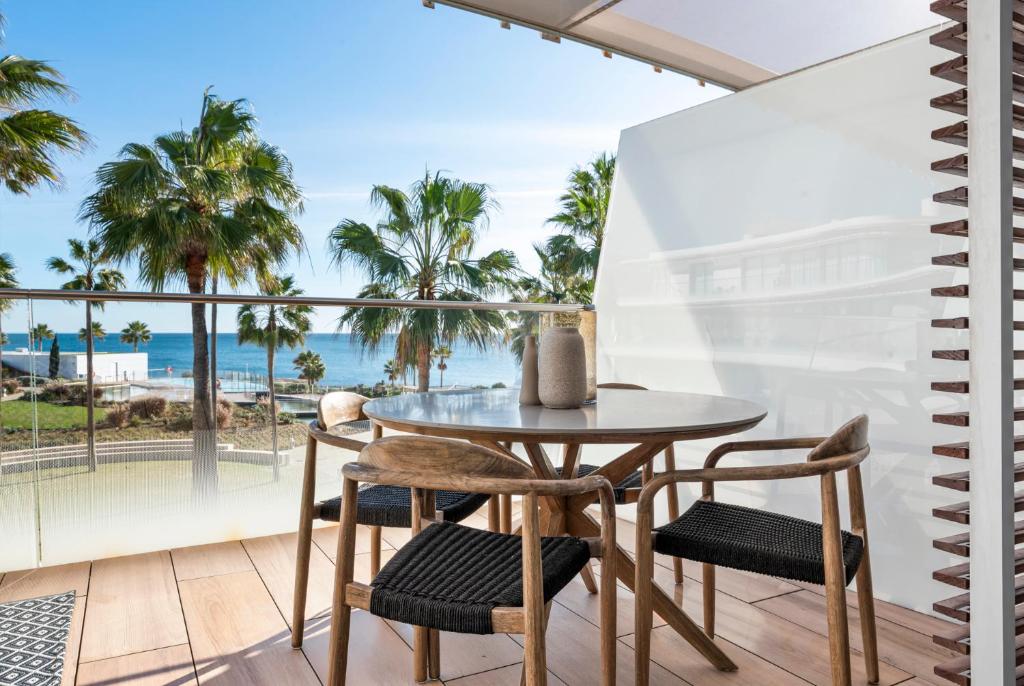 a table and chairs on a balcony with a view of the ocean at Casa Costa Tropical in Estepona
