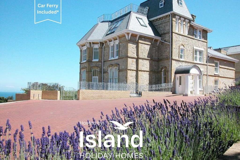 a large house with purple flowers in front of it at Sea View in Shanklin