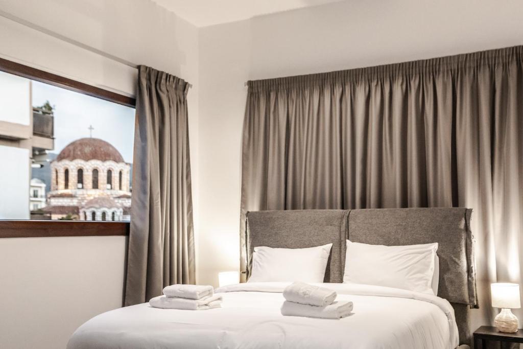 a hotel room with a bed with towels on it at Ermou Residences in Volos