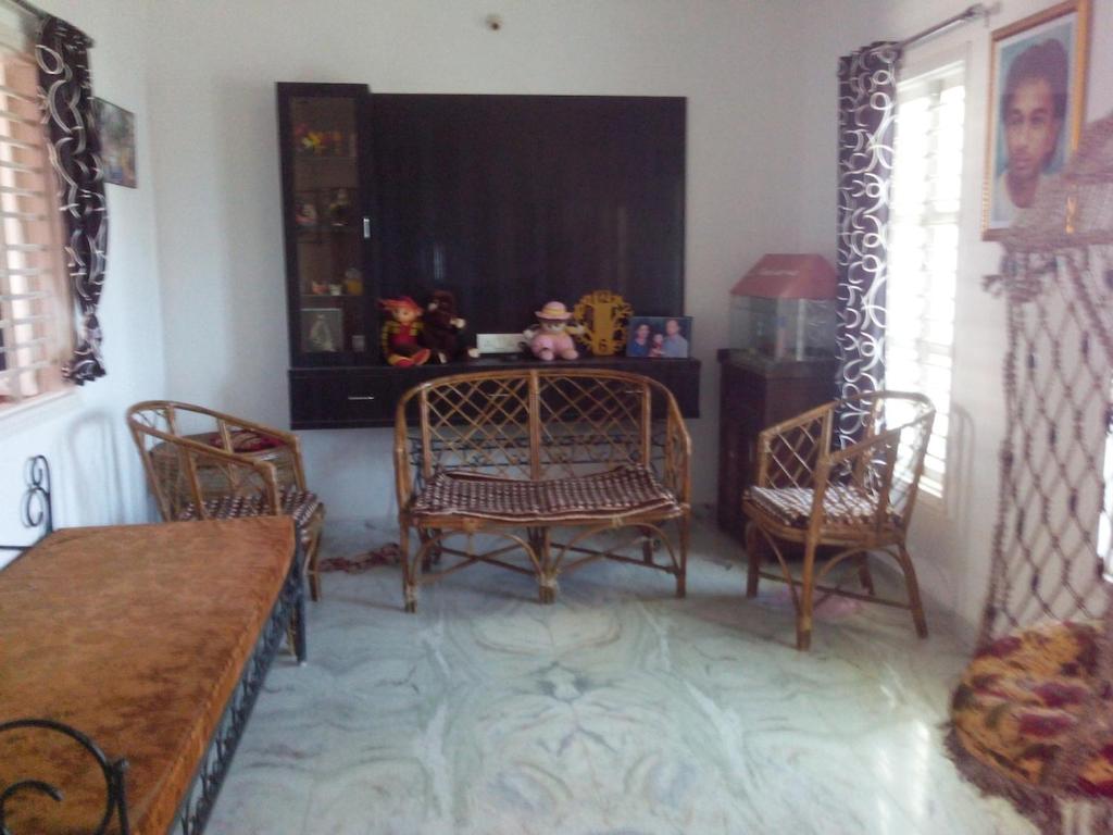 a living room with two chairs and a table at Raina's Home in Bhuj