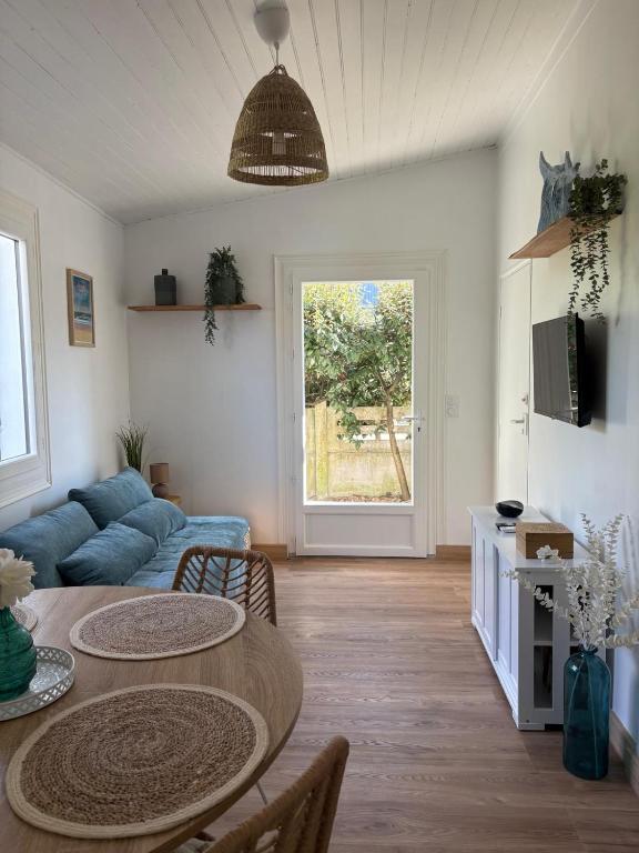 a living room with a table and a blue couch at Andernos les pieds dans l eau in Andernos-les-Bains