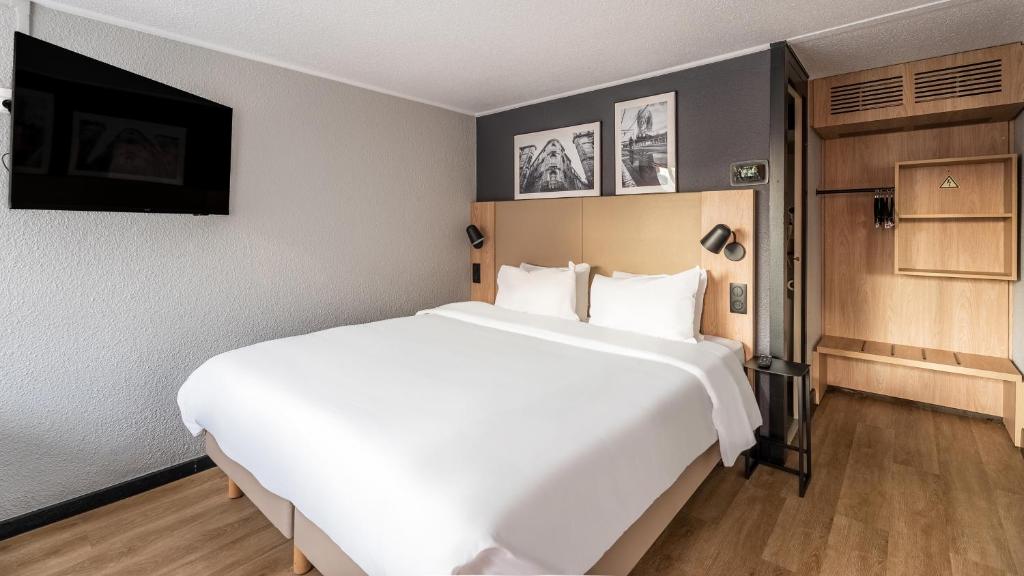a large white bed in a hotel room at Campanile Brest - Gouesnou Aeroport in Gouesnou