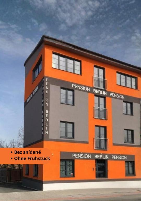an orange and gray building with the words permission permission forgiven at Pension Berlin in Cheb