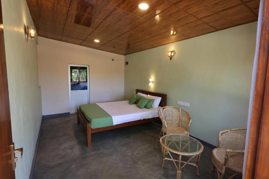 a bedroom with a bed and a table and chairs at Green Heaven in Dickwella