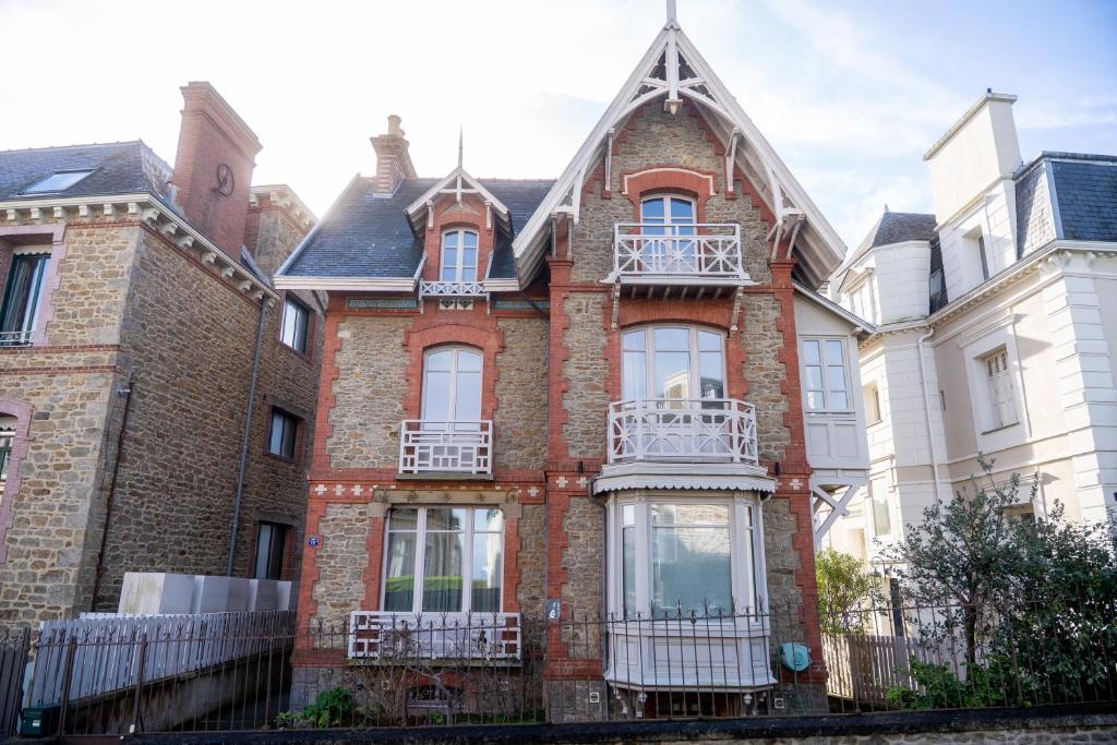 a large brick house with white windows and balconies at Villa Ker Betsy in Dinard