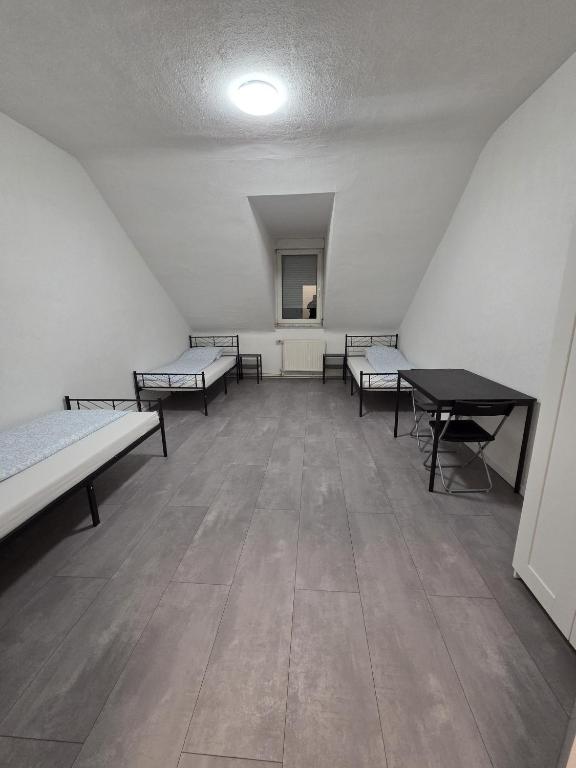 a room with several beds and a table at modernes & einfaches übernachten in Bruchsal