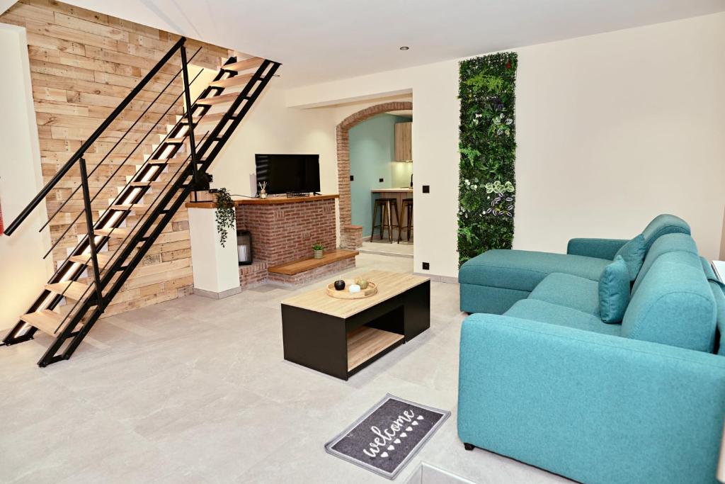 ein Wohnzimmer mit einem blauen Sofa und einer Treppe in der Unterkunft Chez Léon in Brugelette