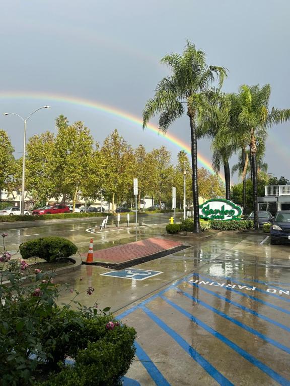 a rainbow over a parking lot with palm trees at Garden Inn Hotel 花園酒店 - Pasadena, San Gabriel - Los Angeles in San Gabriel