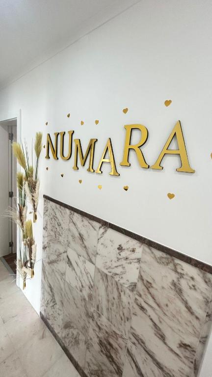 a sign on a wall with a marble counter at Alojamento Numara in Setúbal