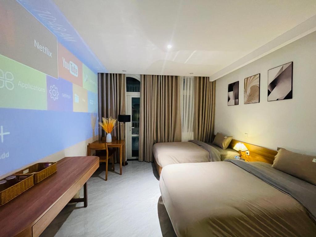 a hotel room with two beds and a table at Sò homestay in Thôn Văn Dương