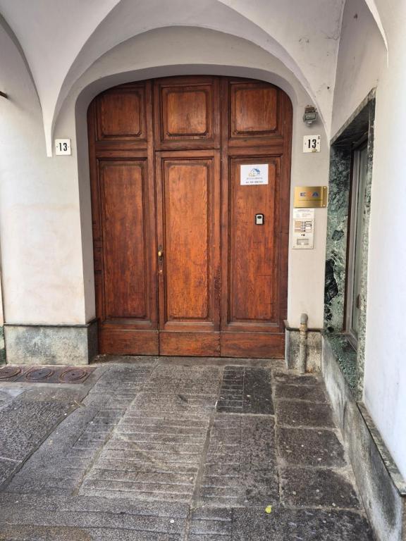 a large wooden door in a building with an archway at Julias house in Biella
