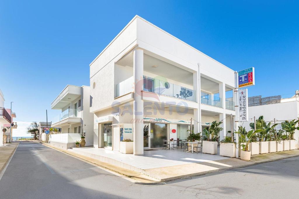 a white building on the side of a street at Residence Stella del Mare in Torre Pali