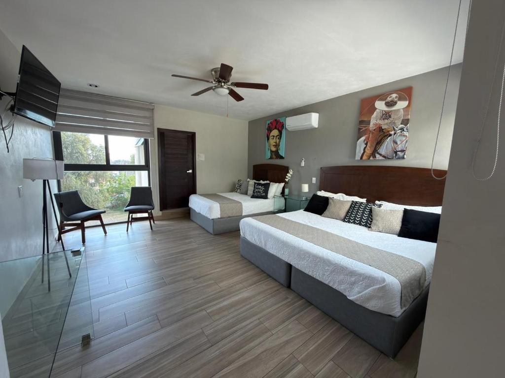 a bedroom with two beds and a ceiling fan at Casa Arandas Hotel - Suits in Arandas
