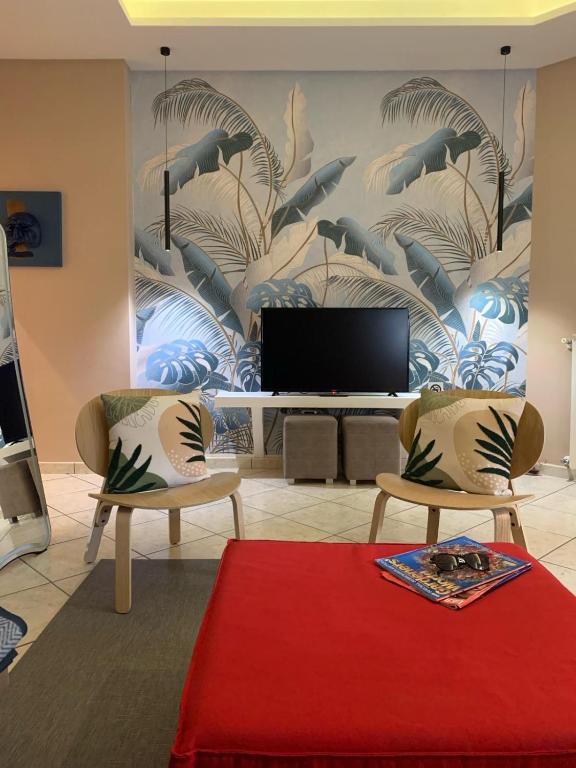 a living room with two chairs and a television at Pompei Home Apartament in Boscoreale
