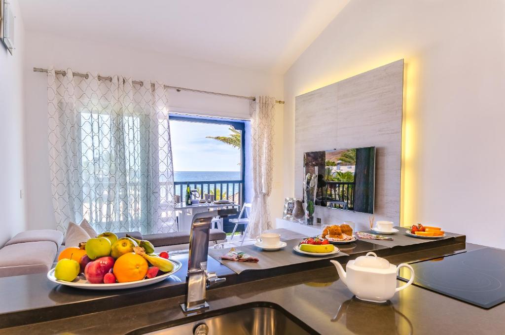 una cocina con una barra con un bol de fruta. en Lidia & Paco Home two bedrooms beachfront en Playa del Aguila