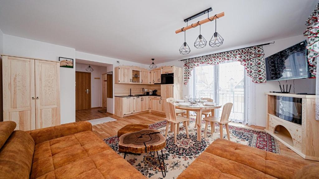 a living room with a couch and a table at Apartament Białka J6 in Białka Tatrzańska
