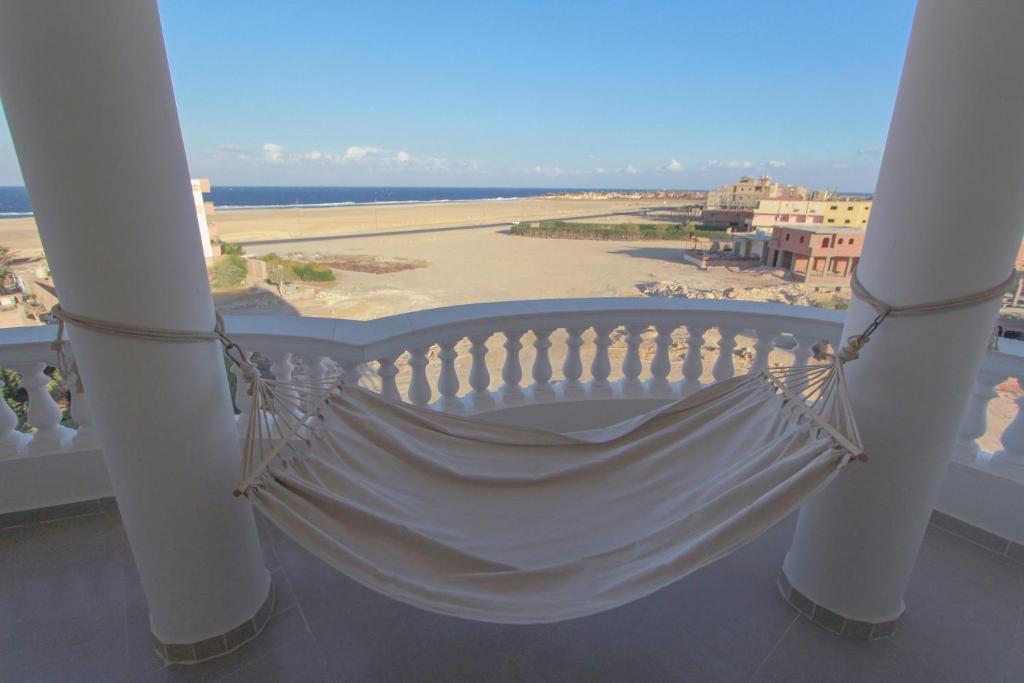a hammock on a balcony with a view of the beach at 36 Southwalk in Quseir