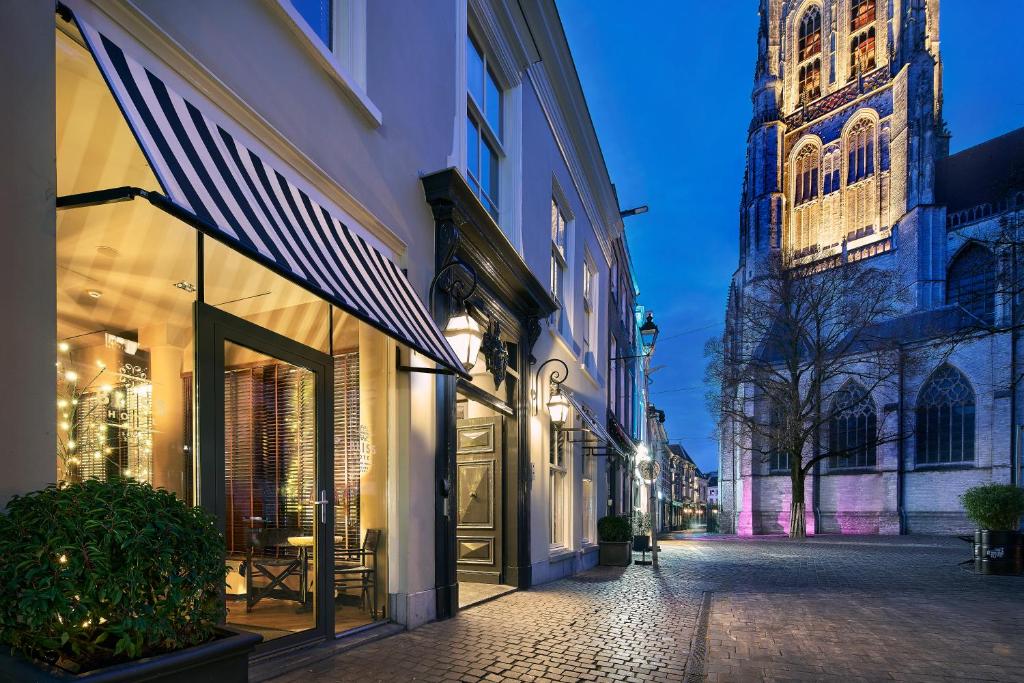 een straat met een gebouw en een klokkentoren bij The Saints Bliss Hotel in Breda
