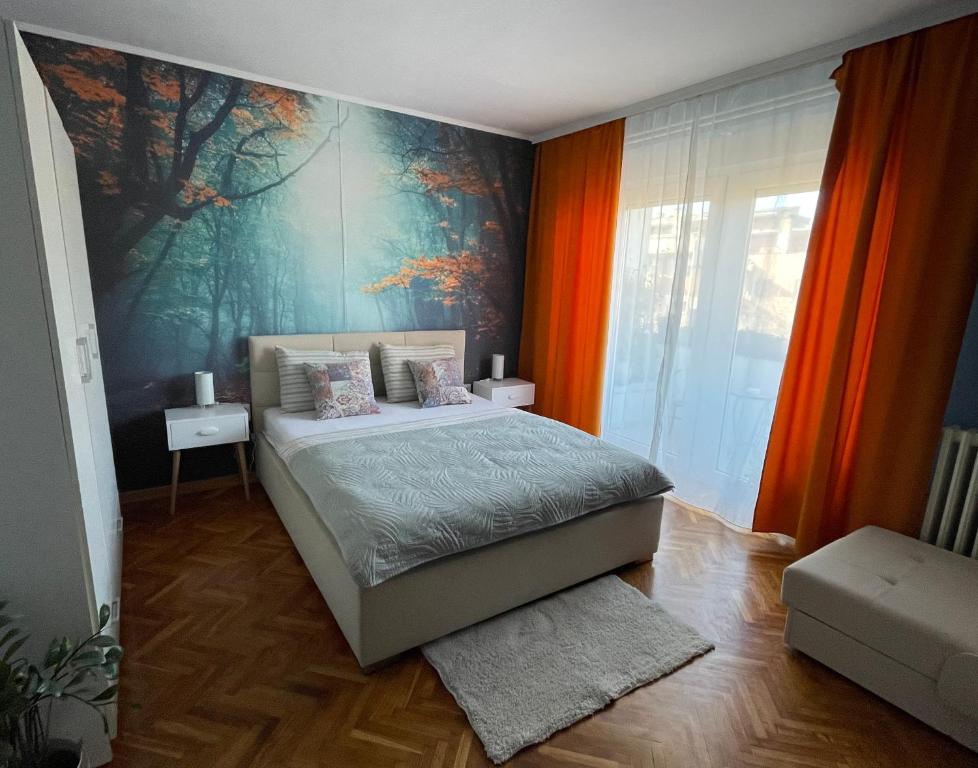 a bedroom with a bed and a painting on the wall at Apartman Avenia in Novi Sad