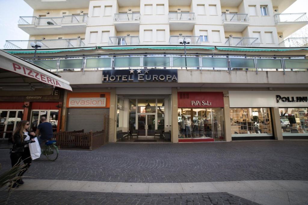 un negozio di fronte a un hotel con persone che camminano davanti di Hotel Europa a Rimini