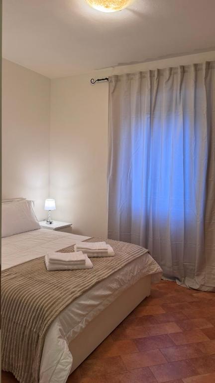 a bedroom with a bed with two towels on it at Casa Rasiglia 3 House Relax in Casenove