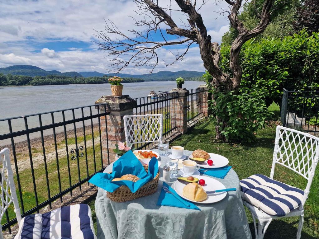 a table with food on it next to the water at Jacuzzi - Riverside - Garden in Kismaros