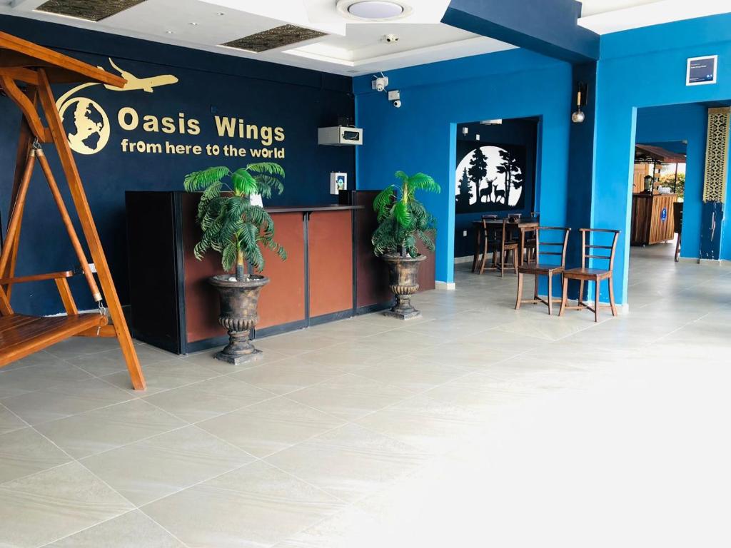 a room with a blue wall with chairs and a counter at Oasis Wings Hotel in Mannar