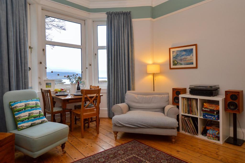 a living room with a chair and a table and a window at Montford Shore in Rothesay