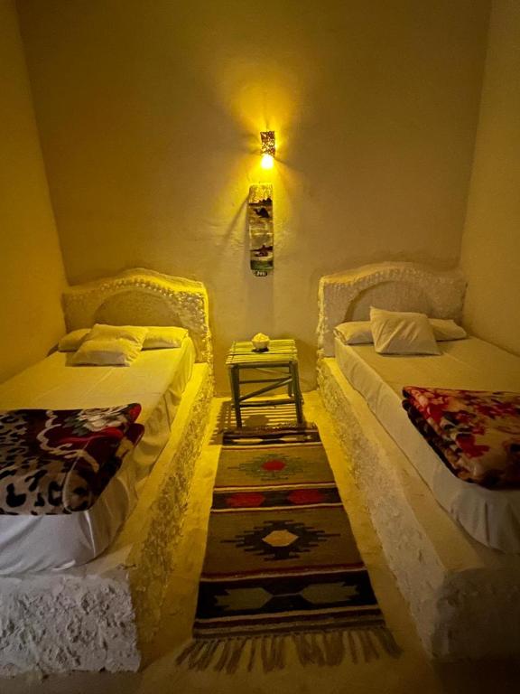 a room with two beds and a table in it at Soliman House Siwa in Siwa