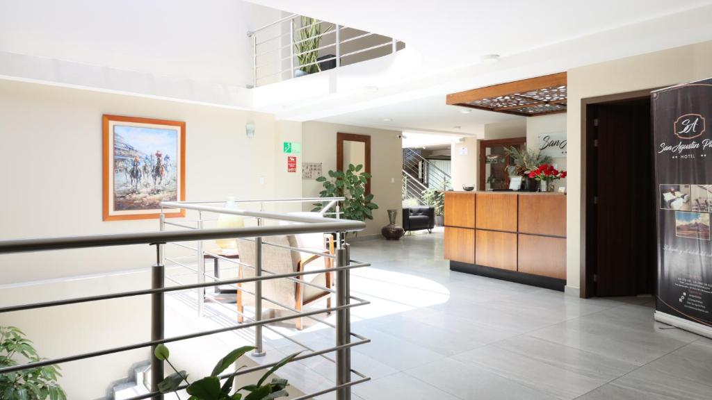 a lobby with a staircase in a building at Hotel San Agustin Plaza in Latacunga