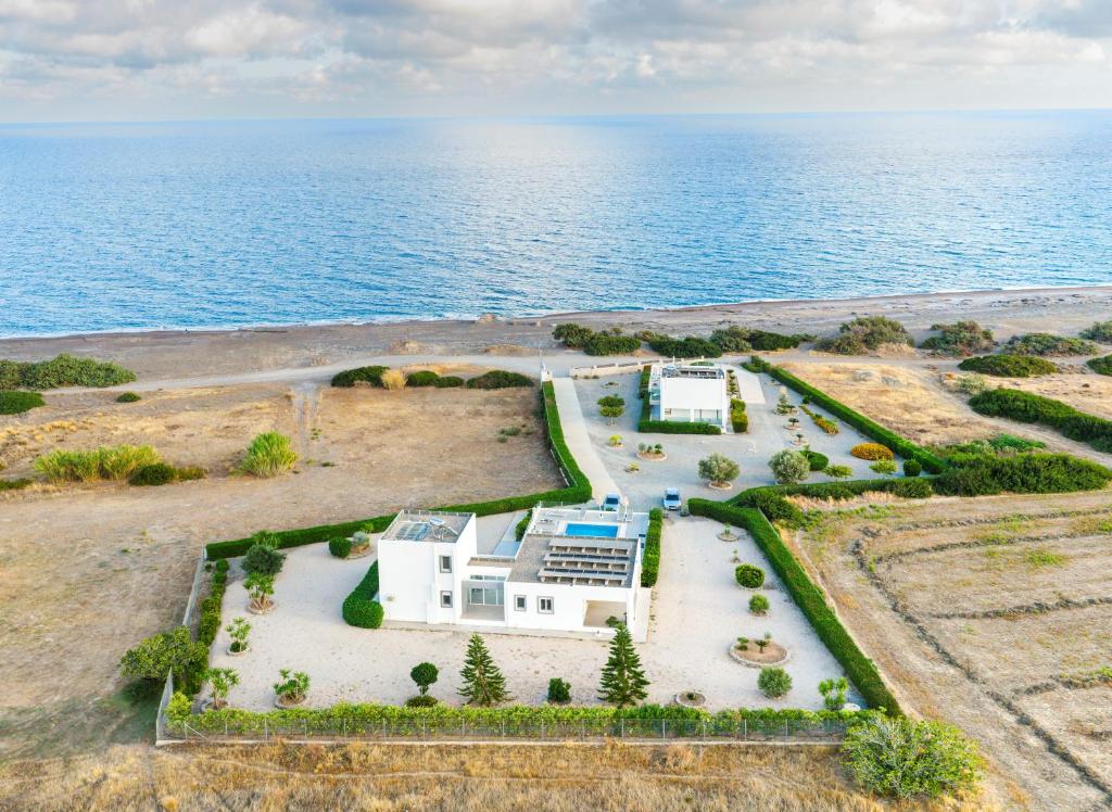an aerial view of a house next to the ocean at Aegean Horizon Beachfront Villas in Gennadi
