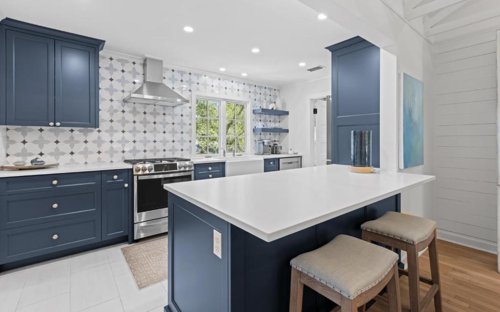 a kitchen with blue cabinets and a white counter top at Three Sisters Bungalow in Santa Rosa Beach
