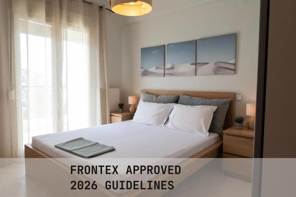 a bedroom with a bed with white sheets and pillows at Prieston Residences in Kilkis