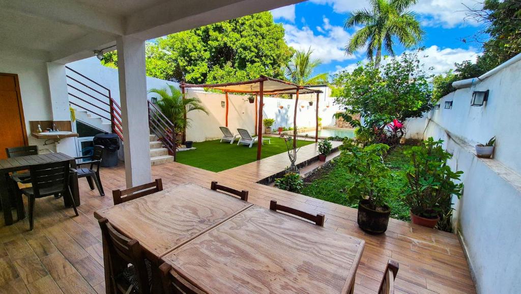 a patio with a wooden table and a garden at Hotel Monserrat in Mérida