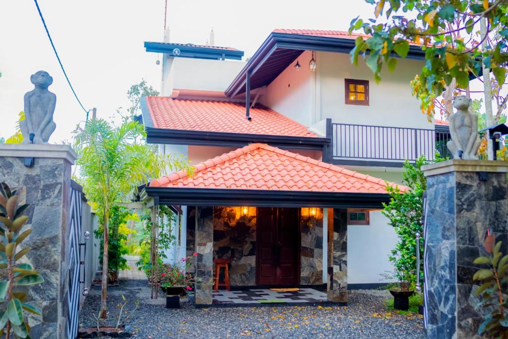an exterior view of a house with a red roof at Casa Monkey 28 in Bentota
