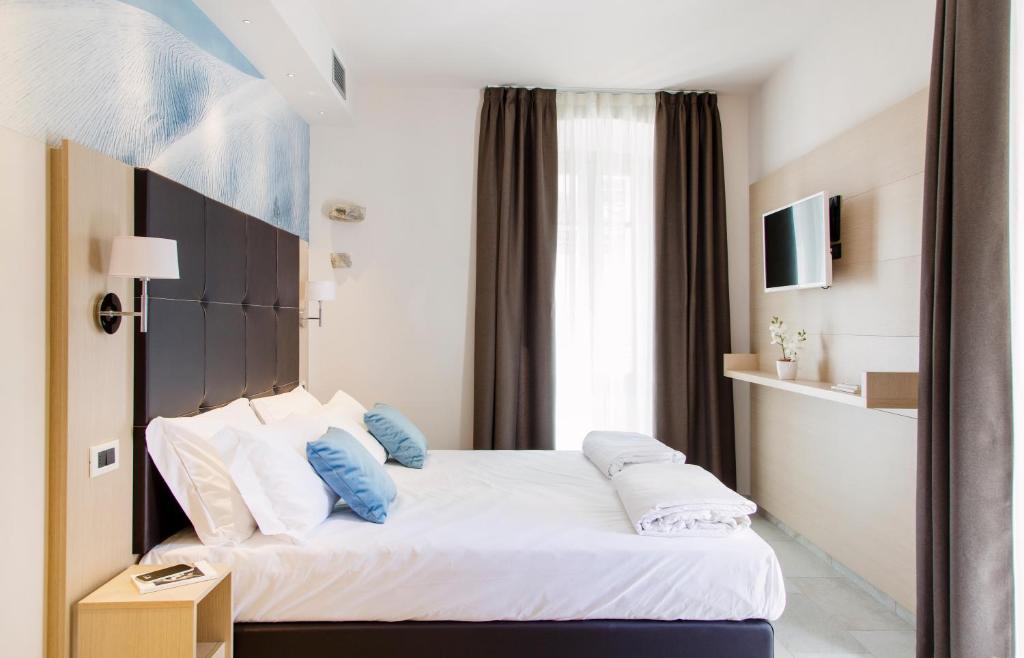 a bedroom with a large bed with blue pillows at Domus Residence in Domodossola