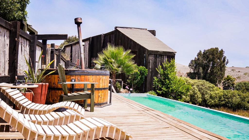 a wooden deck with chairs and a swimming pool at Bed & Breakfast Casa Ziré in Navidad