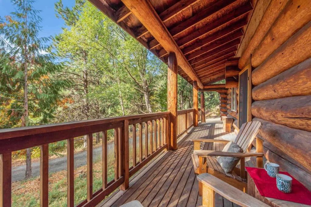 a log cabin porch with a rocking chair on it at Bear Ridge Cabin - Pacific Retreats in Leavenworth