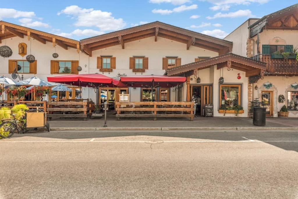 a building with tables and umbrellas in front of it at Klonaqua - Pacific Retreats in Leavenworth