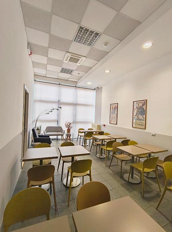 ein leeres Klassenzimmer mit Tischen und Stühlen in der Unterkunft Hotel Marta in Forlì
