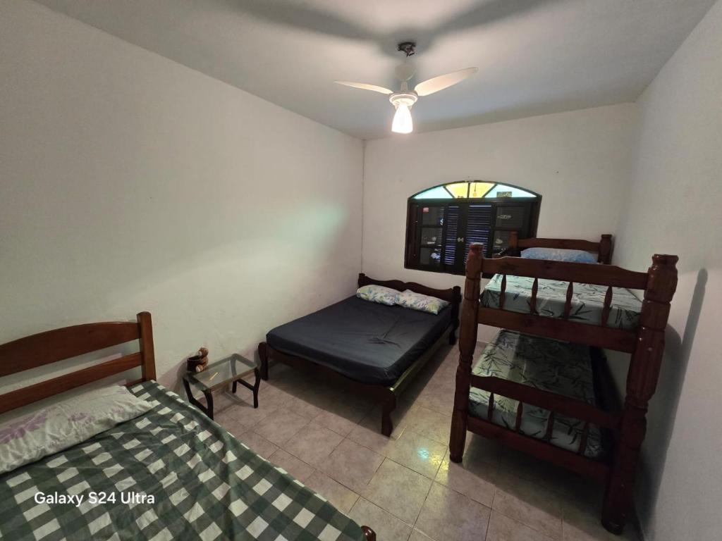 a bedroom with two bunk beds and a window at Família Marques in Itanhaém