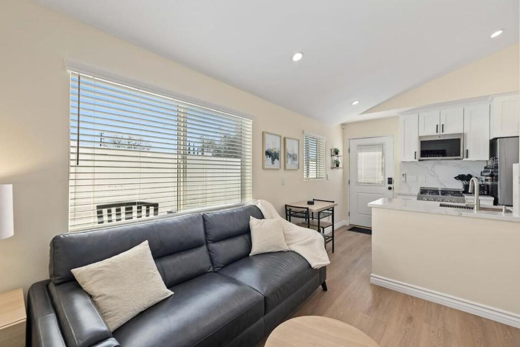 a living room with a couch and a kitchen at Luxury 1BR Suite Kitchen, Fireplace, Laundry, BBQ in Simi Valley