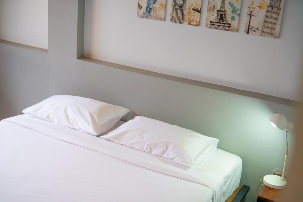 a white bed with two pillows on top of it at THT by Thai Hotel Krabi in Krabi