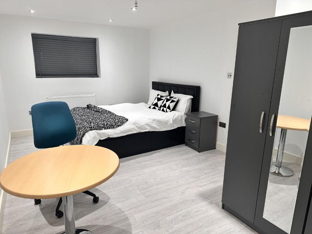 a bedroom with a bed and a table and a desk at Large Double Bed En-suite Room 20 mins from Heathrow in Burnham