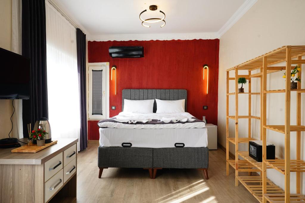 a bedroom with a bed and a red wall at The Apartment Galata in Istanbul