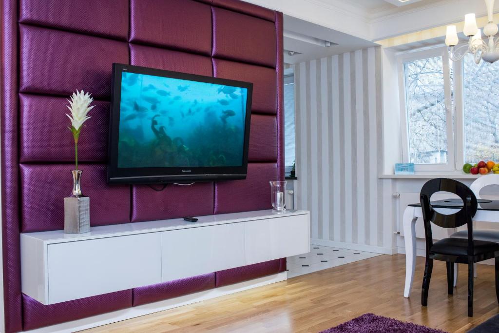 スタロバ・ボラにあるApartament Popiełuszki 39の紫の壁にテレビ付きのリビングルーム