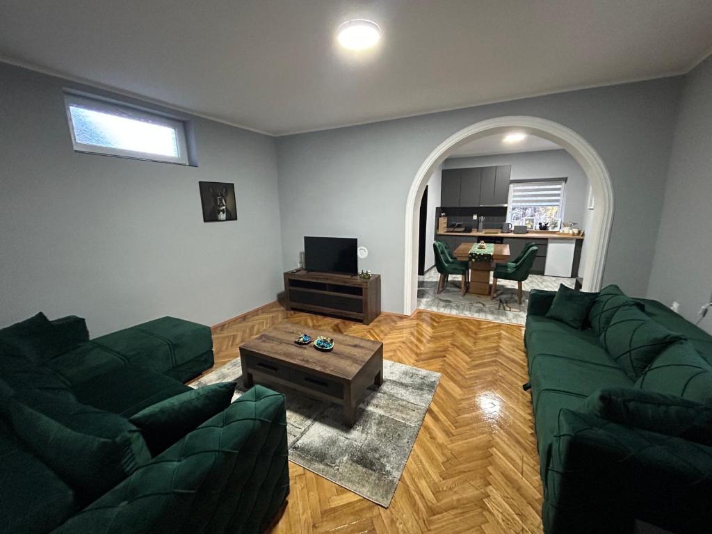 a living room with two green couches and a table at MONA app Apatin in Apatin